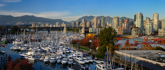 Panorama of boats moored at Granville Island Boat Yard and Burrard bridge and Coastal mountains Vancouver