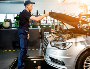 Car mechanic repair engine at service station. Car repair