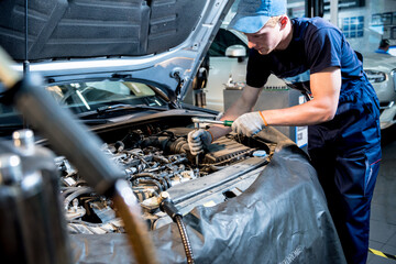Car mechanic repair engine at service station. Car repair