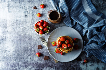 Pancakes with chocolate nutella filling decorated with strawberries