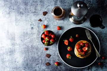 Pancakes with chocolate nutella filling decorated with strawberries