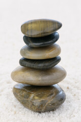 Fototapeta na wymiar Stack of balanced polished rocks on white quartz pebbles to aid Zen contemplation