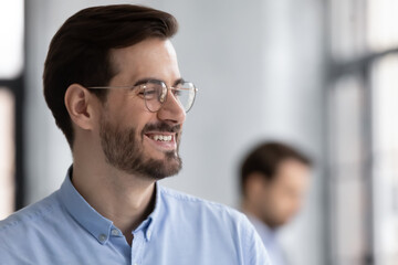 Naklejka premium Close up profile smiling successful businessman wearing glasses looking to aside, business vision concept, overjoyed executive company owner dreaming, pondering project strategy or startup idea