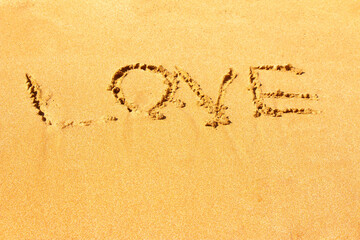 The inscription love on the sea sandy beach