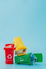 Yellow, green and red recycle bins with recycle symbol on blue background. Keep city tidy, Leaves the recycling symbol. Nature protection concept