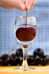 a glass of red cherry tincture and a cherry inside