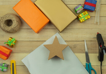 Wrapping gifts with hands in gift paper on the table as a background