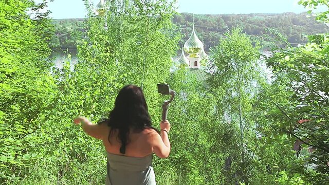 Woman blogging from her mobile phone about travel talks about the temple.