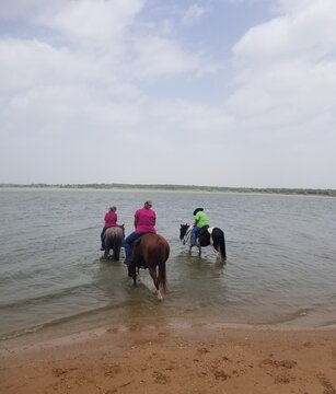 Horseback trail ride by a texas lake