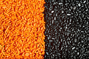 Orange and black unmixed sprinkles macro background, halloween theme