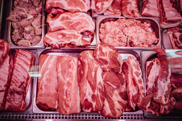 Red raw meat shop window. Fresh and cool meat collection. Meat shop. A full-filled with cold meat fridge.