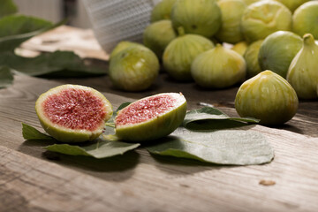 Green Figs, cut slices and leaves on old wooden table