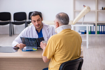 Fototapeta premium Old neck injured man visiting young male doctor radiologist