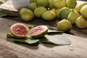Green Figs, cut slices and leaves on old wooden table