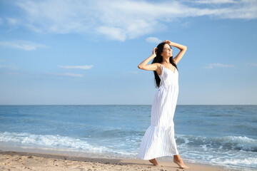 Fototapeta na wymiar Young beautiful woman at beach on sunny day