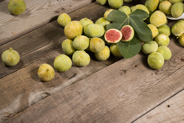 Green Figs, cut slices and leaves on old wooden table