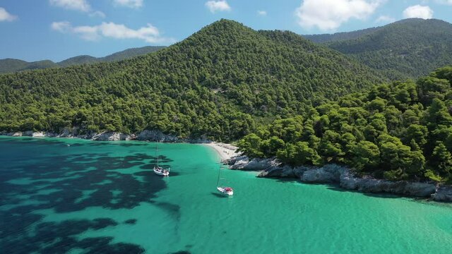 Aerial drone video of famous turquoise pebble paradise beach of Kastani covered with pine trees where famous Mamma Mia movie was filmed, Skopelos island, Sporades, Greece