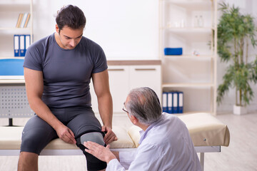 Fototapeta premium Young male patient visiting old doctor traumatologist