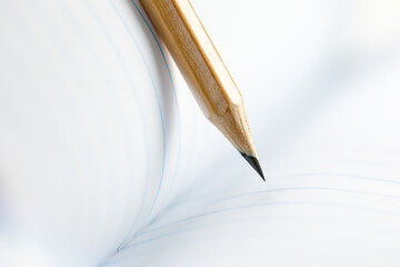 Closeup of sharp graphite pencil on white paper of notebook.  Concept of The National Day of Knowledge or International literacy day.
