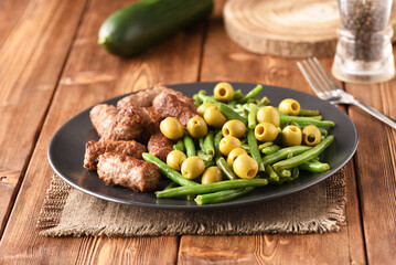 Bean pods, olive and fried Turkish cutlets.