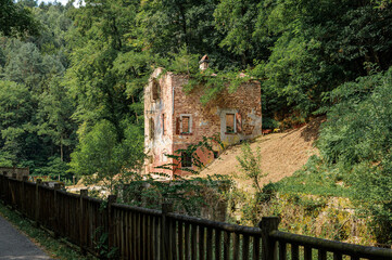 Fototapeta na wymiar On the edge of an abandoned canal, a lock keeper's house in ruins.