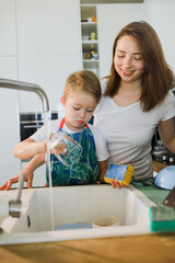 mother and son wash dishes together.
