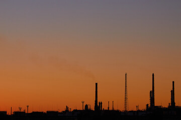 Fototapeta na wymiar Dramatic sunset on the sky and coal power plant factory. Petrochemical industrial plant. Oil and gas refinery tower in silhouette. Refinery for petroleum products