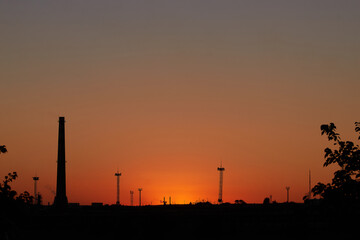 Dramatic sunset on the sky and coal power plant factory. Petrochemical industrial plant. Oil and gas refinery tower in silhouette. Refinery for petroleum products