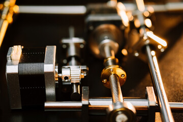 motor and guides for the laser machine. details of the engraving machine, black warm background,...