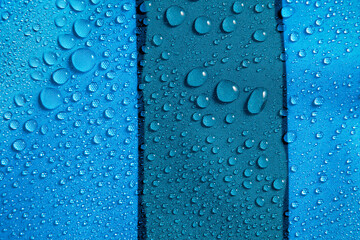 Naklejka na ściany i meble Abstract background of blue hydrophobic fabrics with water drops