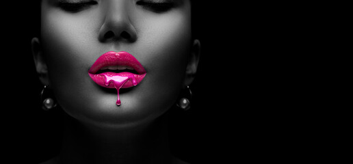 Purple Paint dripping, lipgloss drops on sexy lips, bright liquid paint on beautiful model girl's mouth. Lipstick. Make-up. Beauty face makeup, close up. Isolated on black background