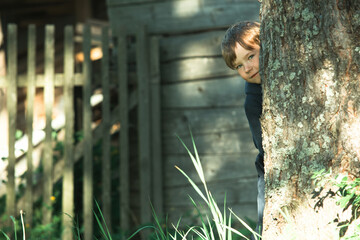 A small boy plays near a village house.