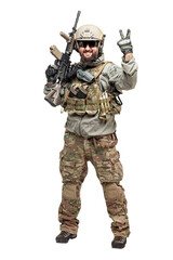 American soldier in military equipment with a rifle on a white background makes a good sign, commando with a weapon in uniform shows ok gesture
