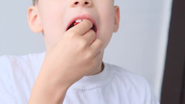 boy, kid holds in his mouth and eats gelatinous sweets, gummy bear, concept of children's delicacy, healthy and unhealthy food, halal food
