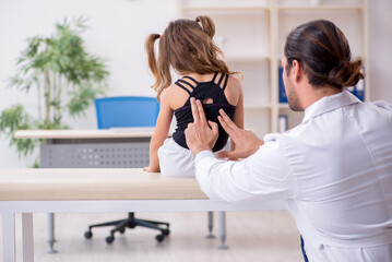 Small girl visiting young male doctor - obrazy, fototapety, plakaty