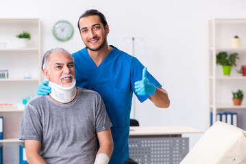 Young male doctor and old patient in first aid concept