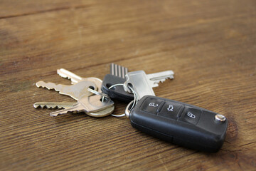 bunch of keys from the locks and the car lies on an old wooden table, natural textures, concept of discovery, secrets, clues, buying real estate, houses, apartments, mortgages, housing loans, cars