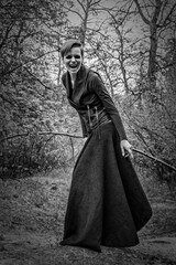 Fototapeta na wymiar evil witch or female vampire, in the forest, bares her teeth aggressively with intent to attack, concept of halloween horror, fear, mysticism and witchcraft