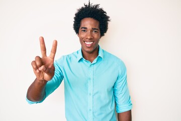 Handsome african american man with afro hair wearing casual clothes showing and pointing up with fingers number two while smiling confident and happy.
