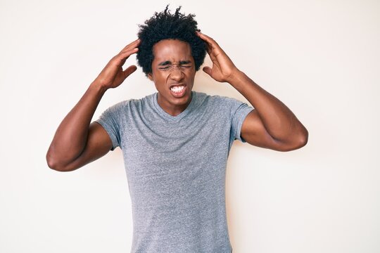 Handsome african american man with afro hair wearing casual clothes with hand on head, headache because stress. suffering migraine.
