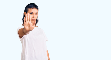 Young woman wearing casual clothes doing stop sing with palm of the hand. warning expression with...