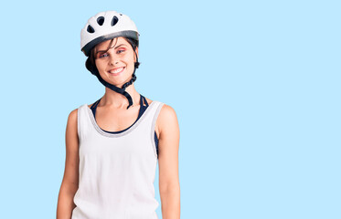 Beautiful young woman with short hair wearing bike helmet looking positive and happy standing and smiling with a confident smile showing teeth