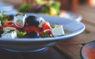 A Caesar salad on white plate on dark wooden table