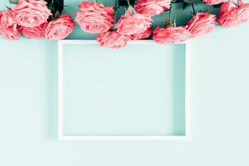 Beautiful flowers composition. Photo Frame, pink rose flowers on pastel blue background. Valentines Day, Womens day, Mother's day, concept, design. Flat lay, top view, copy space