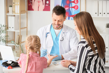 Doctor measuring blood sugar level of little girl in clinic