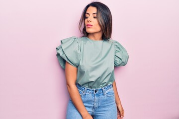 Young beautiful brunette woman wearing casual clothes standing over isolated pink background