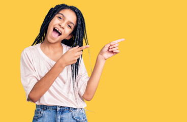 Cute african american girl wearing casual clothes smiling and looking at the camera pointing with two hands and fingers to the side.