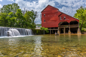 An old red mill and a dam.