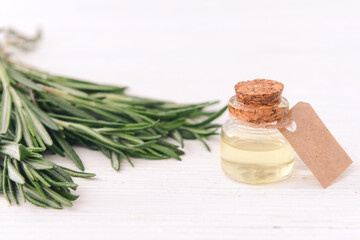 Fototapeta na wymiar Bottle of rosemary essential oil on table