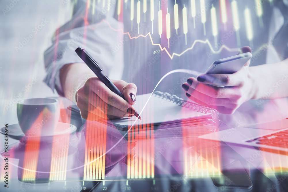 Poster double exposure of financial graph sketch hologram and woman holding and using a mobile device. stoc